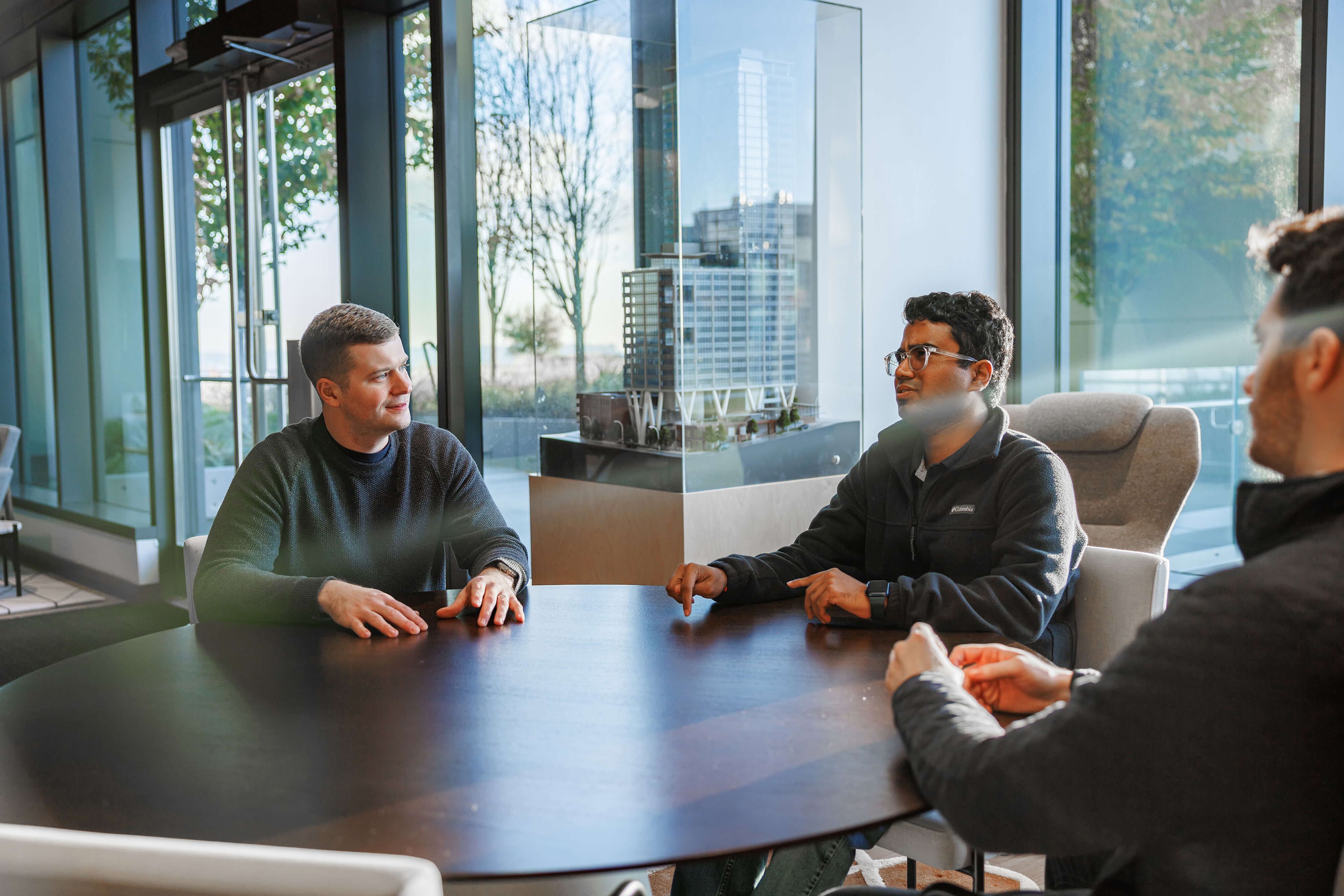 Three Protect AI employees sitting at a conference table having a discussion